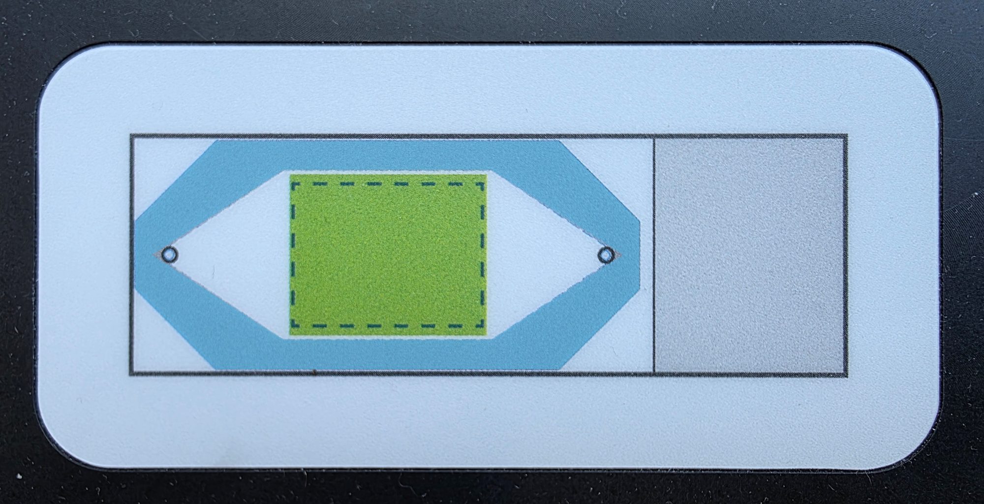 An image showing the slide template on the flow cell assembly tool, with the imageable area shaded in green and the flow cell coverslip border area shaded in blue.