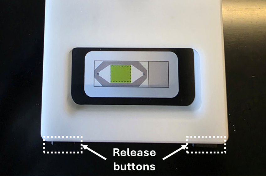 An image showing the release buttons on the arm of the flow cell assembly tool.